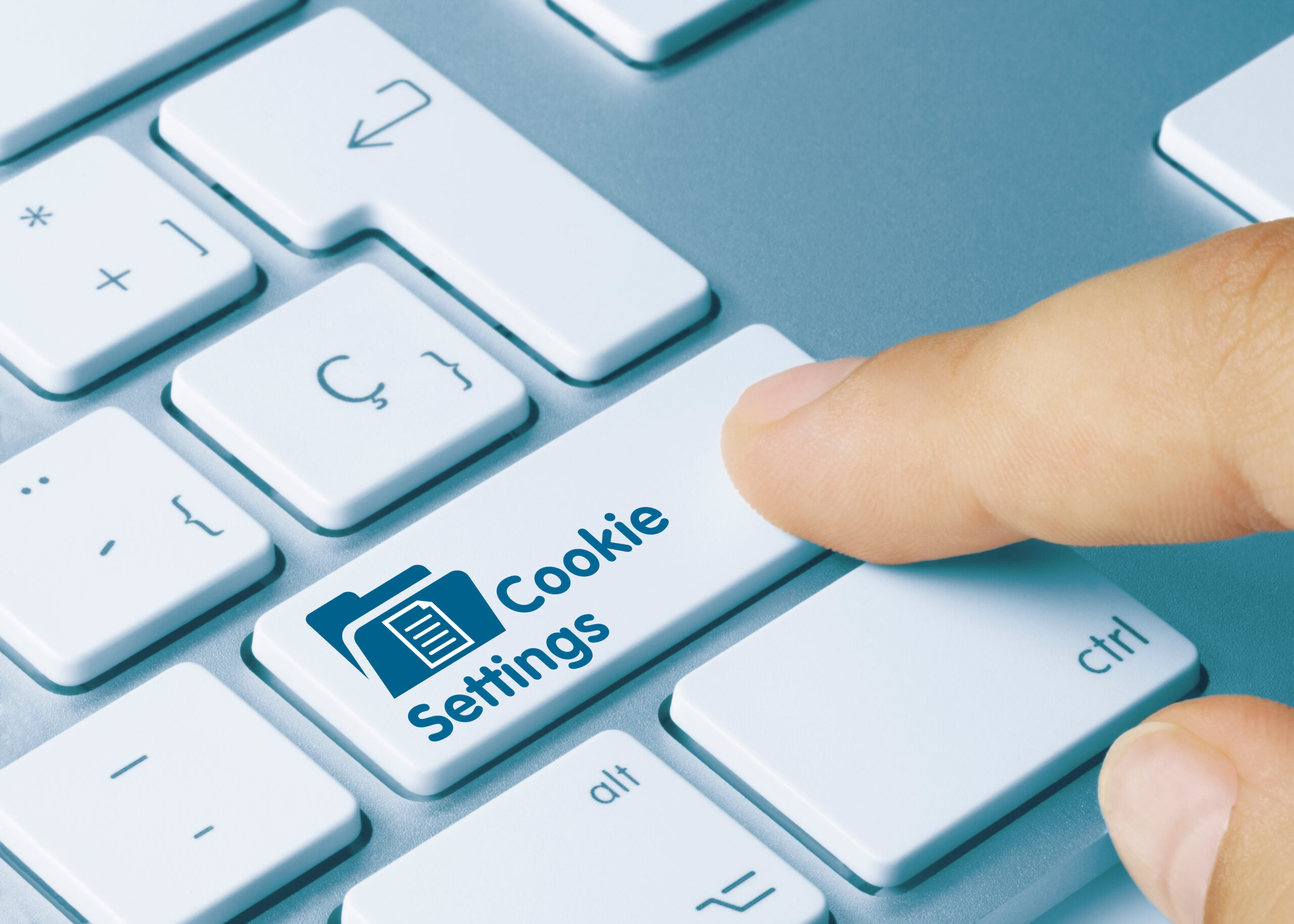 A keyboard with finger pressing a button labeled "Cookie Settings"